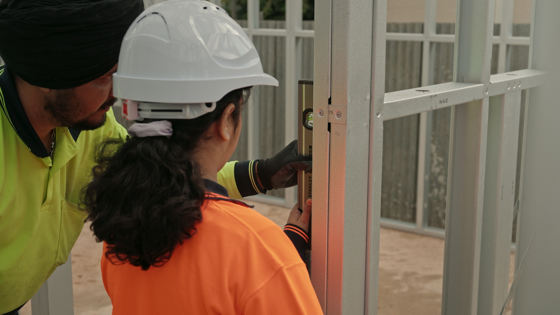 SF Prestige Homes team members checking a wall frame with a spirit level on site
